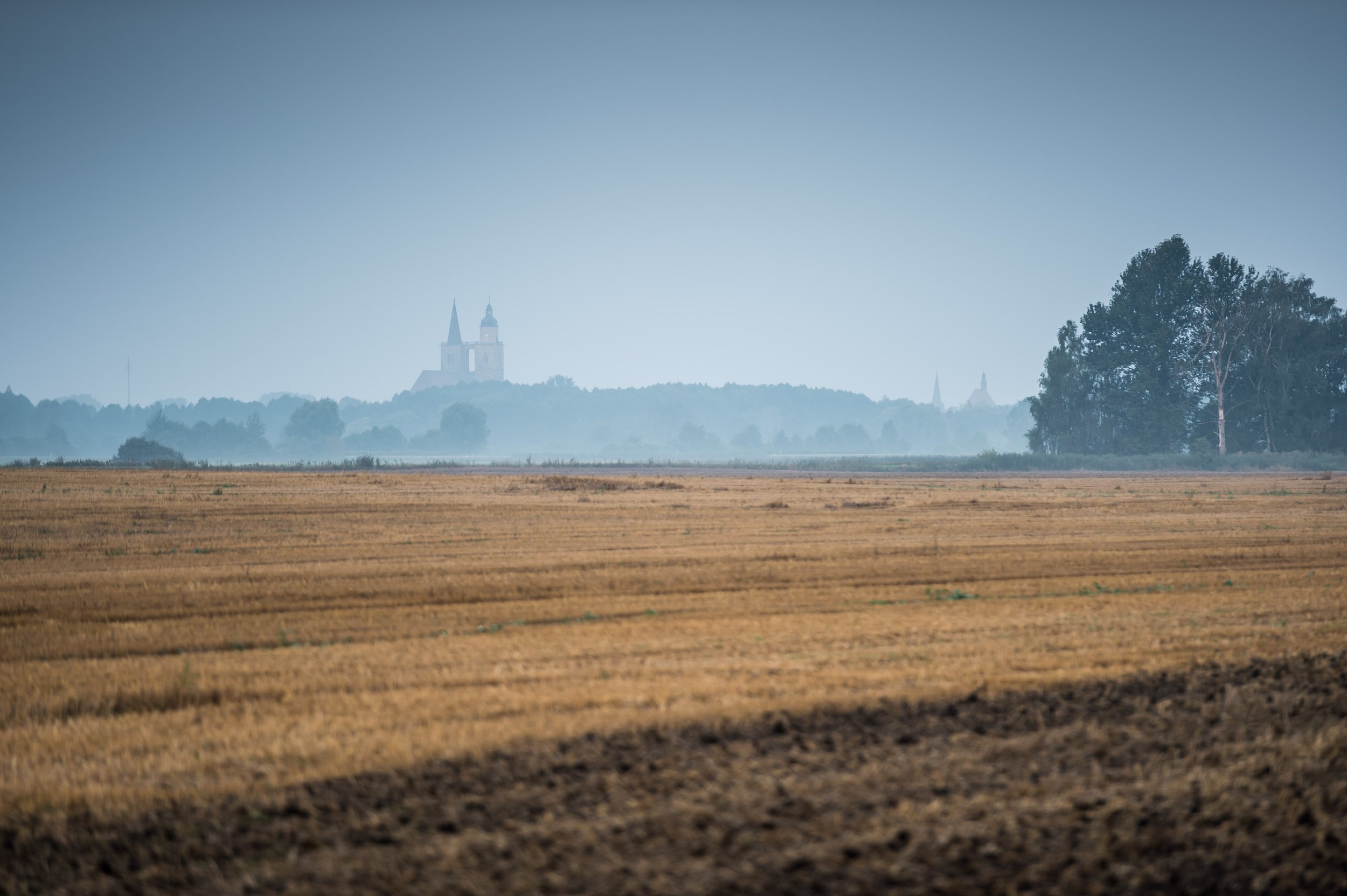 Brandenburgische Landschaft: weite Felder, Wälder und mittelalterliche Kirche nahe Jüterbog, 45 Minuten südlich von Berlin